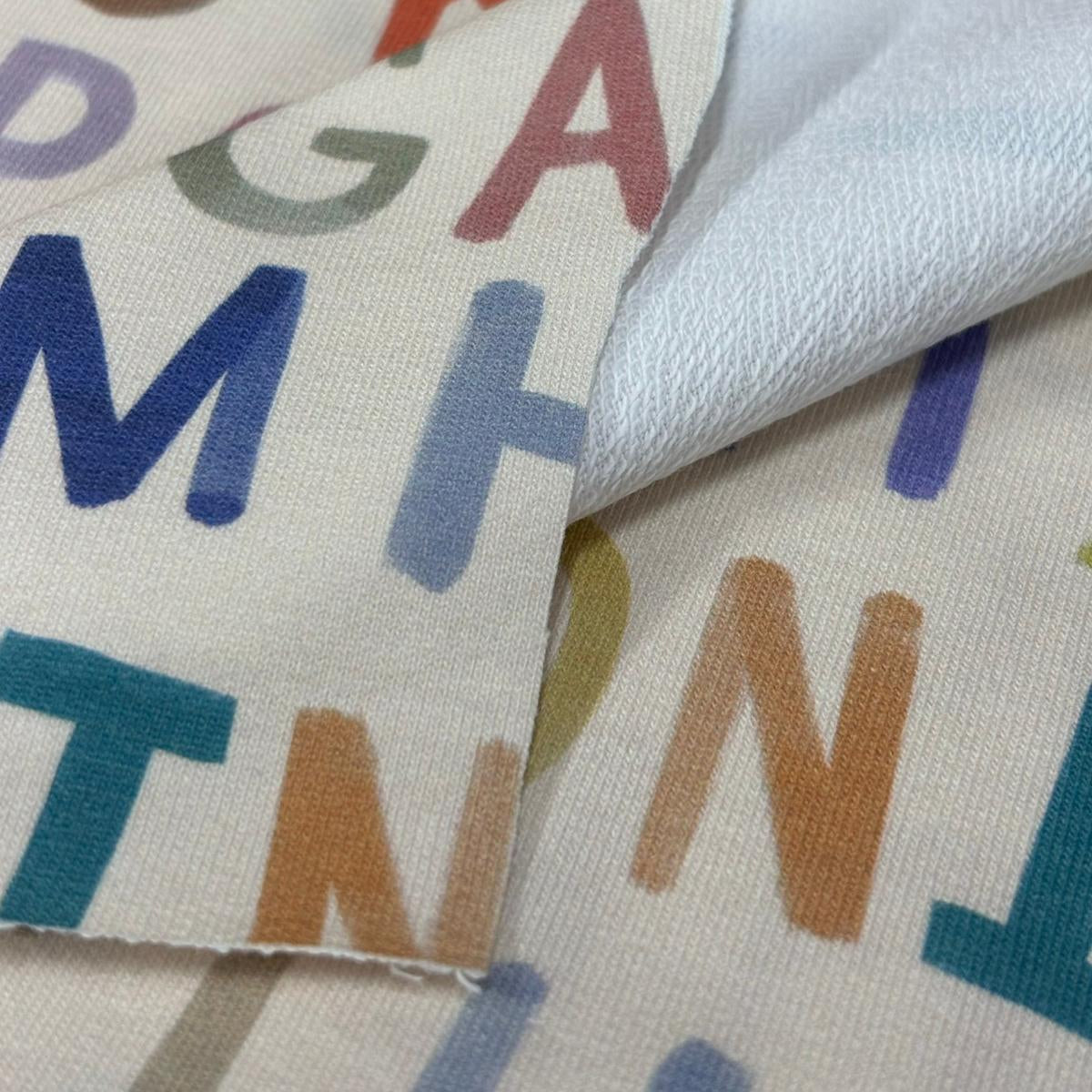 Close-up of fabric with colorful letters on a beige background