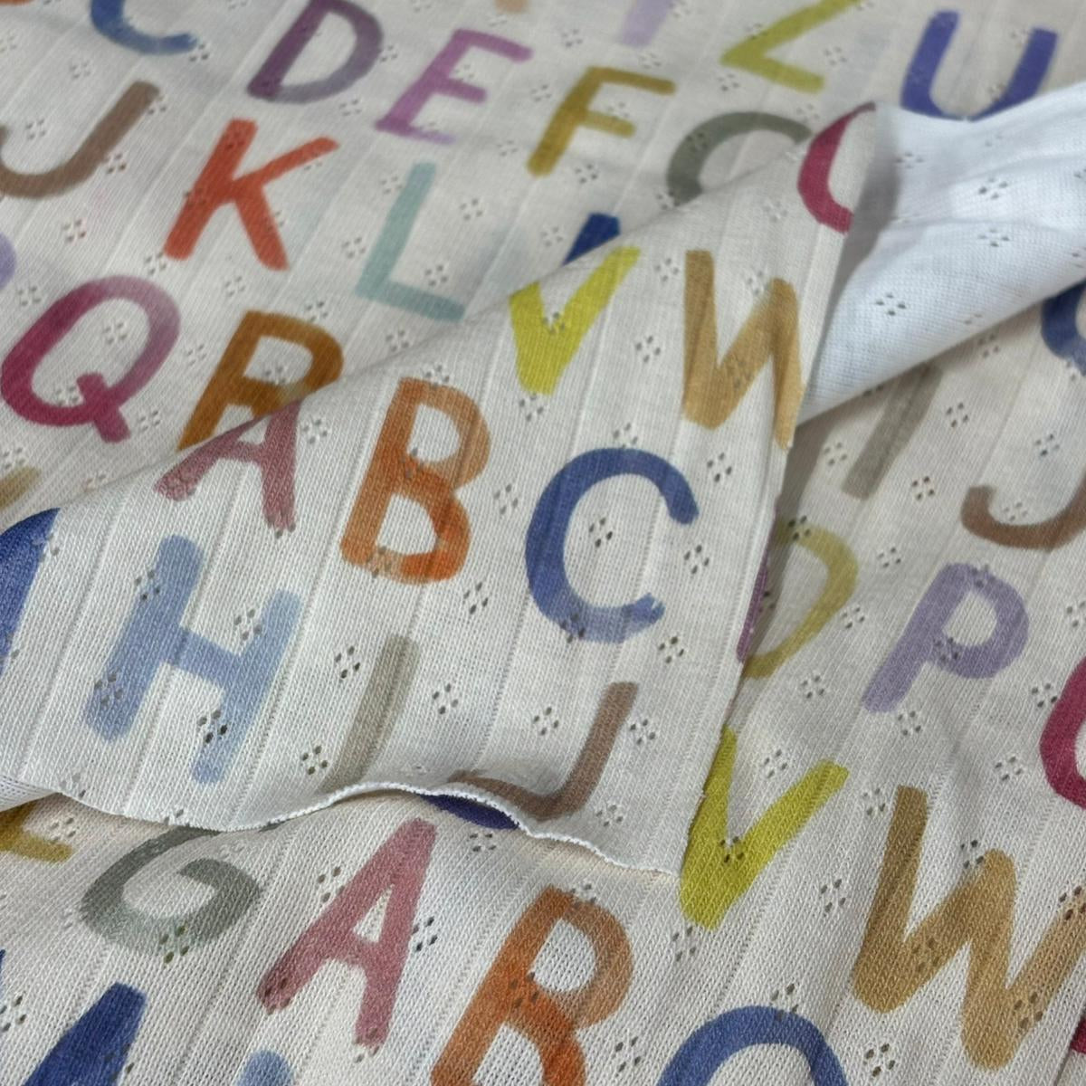 Fabric with colorful letters of the alphabet on a white background