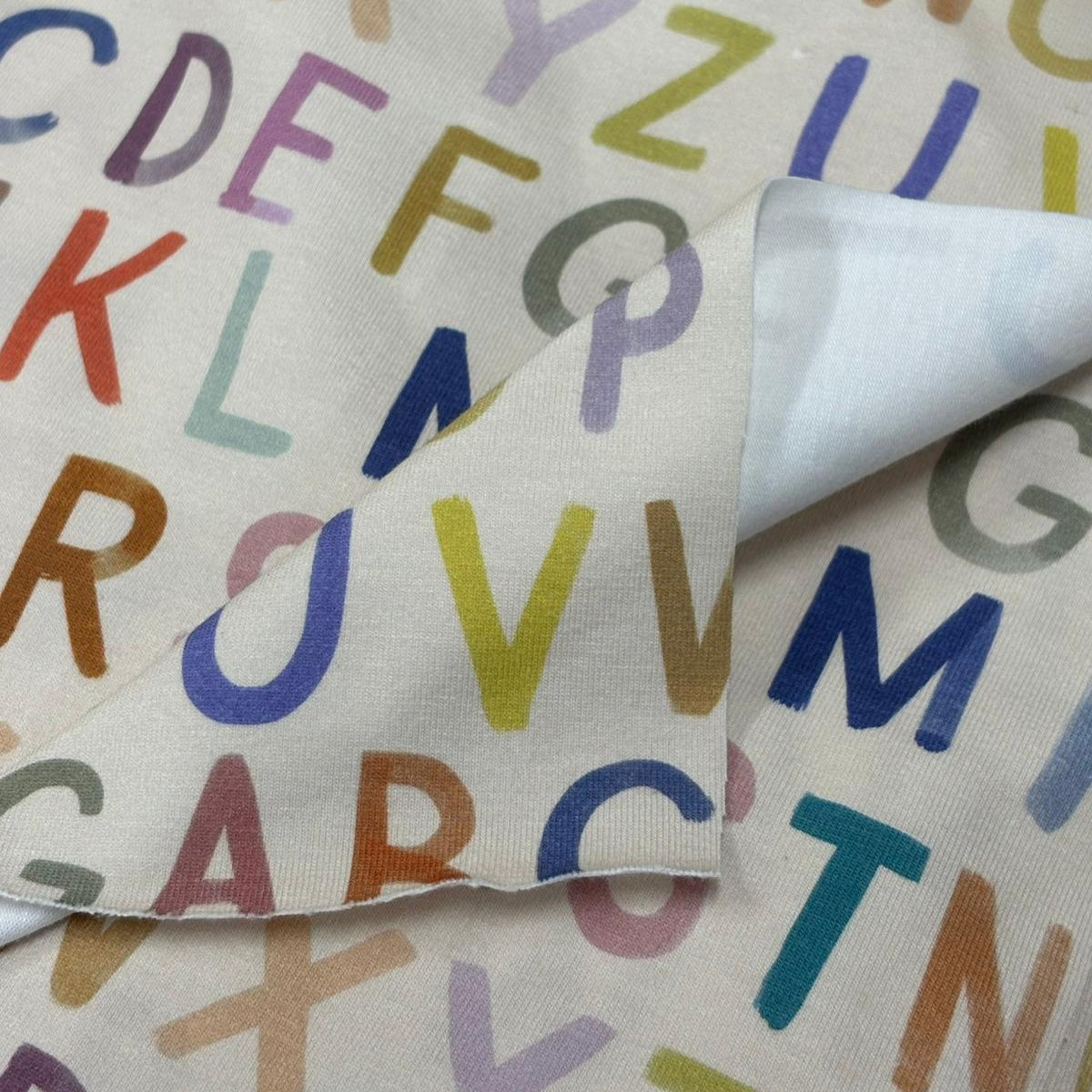 Fabric with colorful letters of the alphabet on a white background