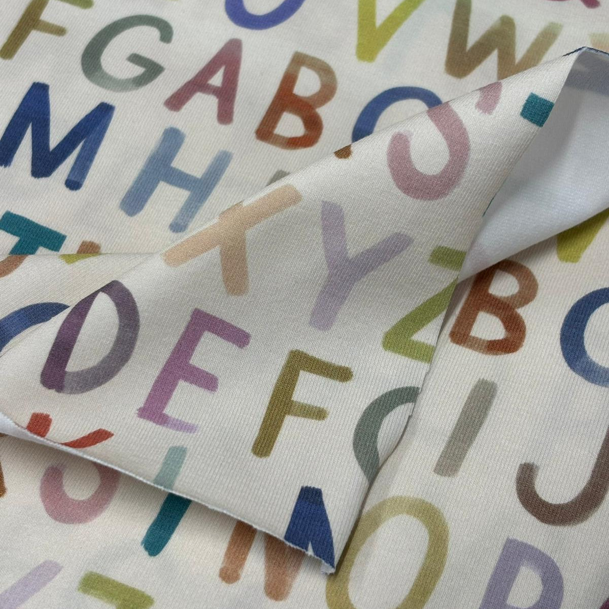 Fabric with colorful letters of the alphabet on a white background